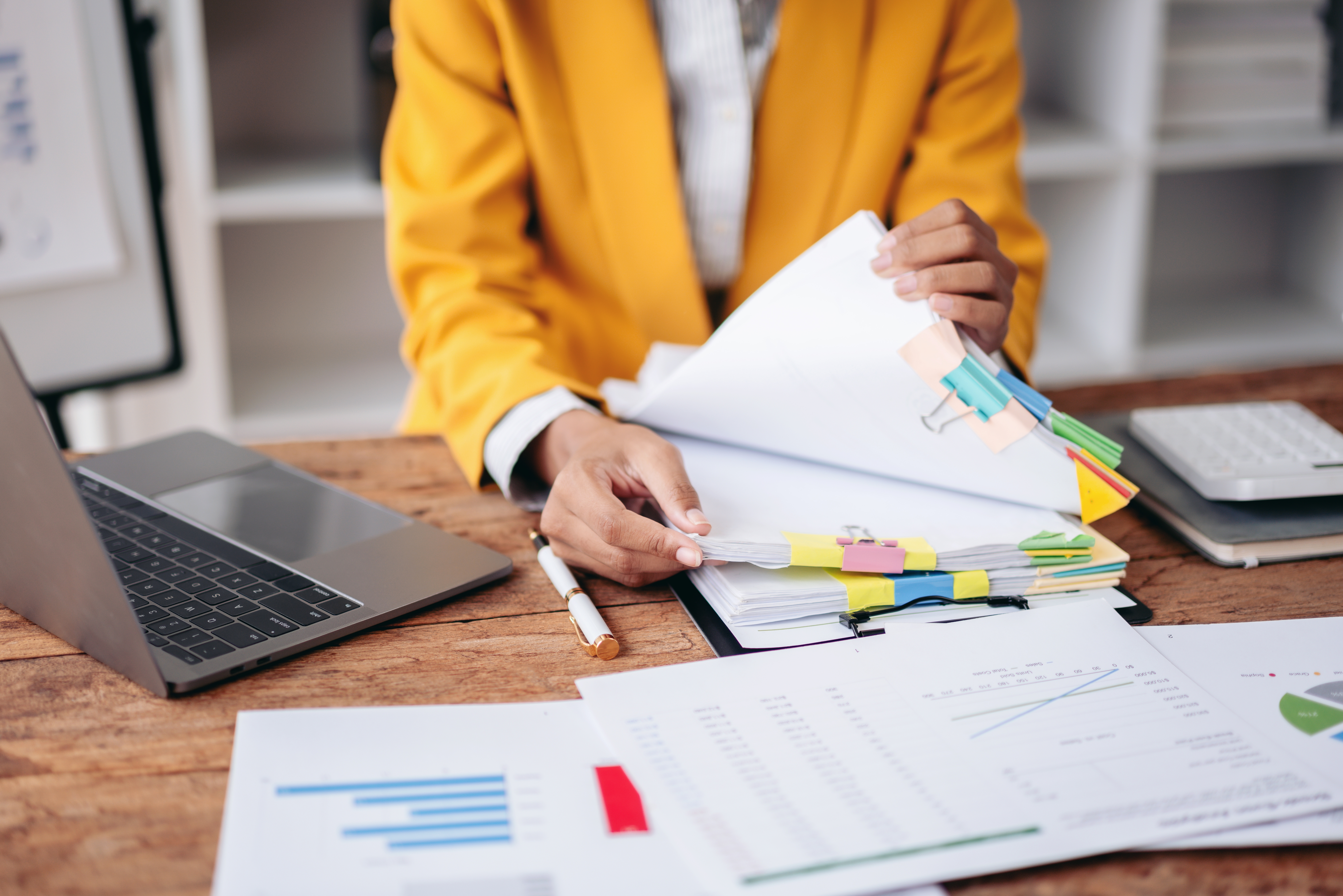 A business professional handling organized paperwork on her desk