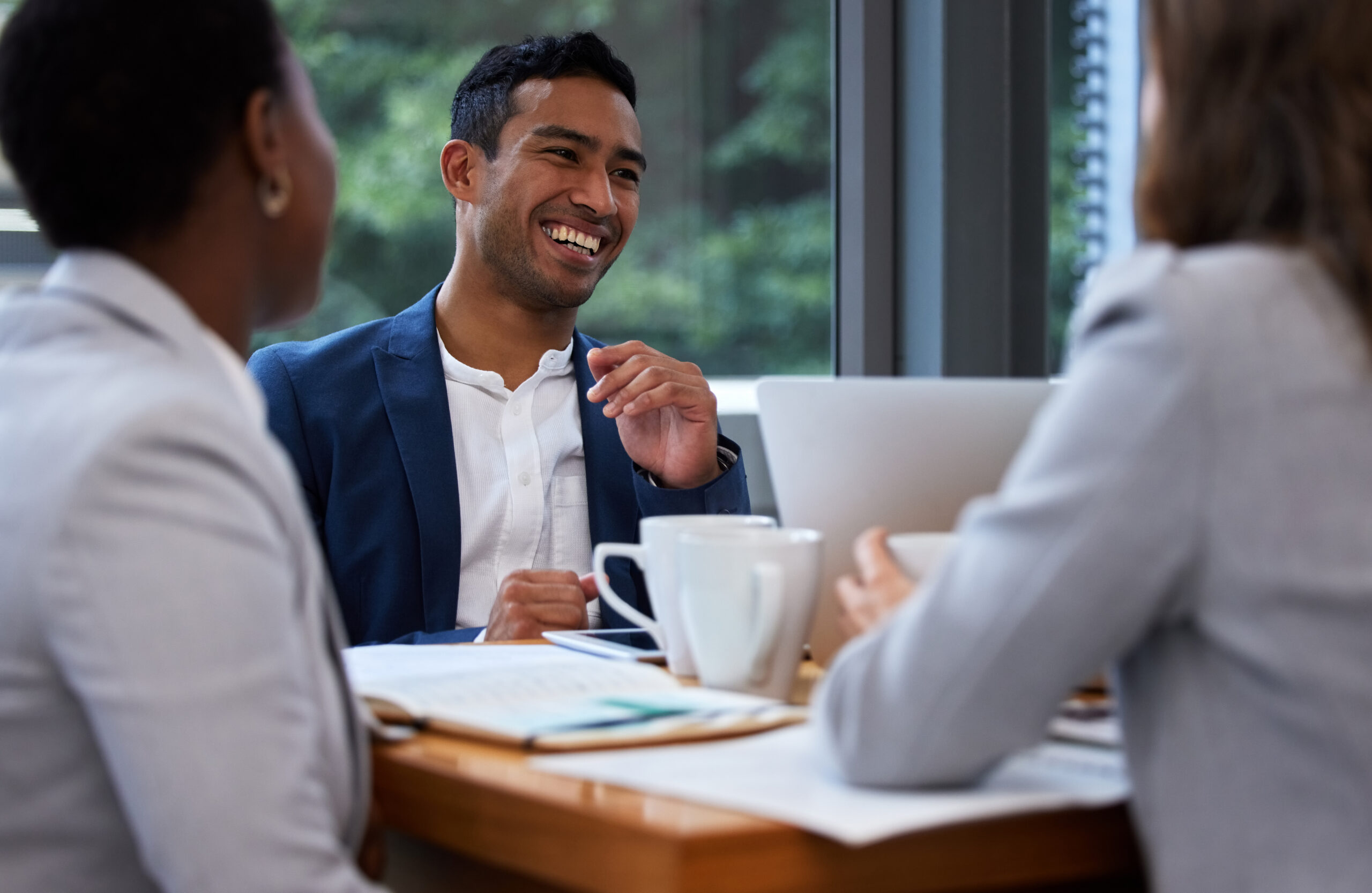 A young business professional having a positive conversation with his colleagues in the office.